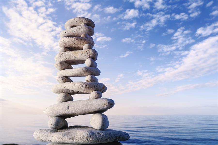 Stack of balanced stones with water background.