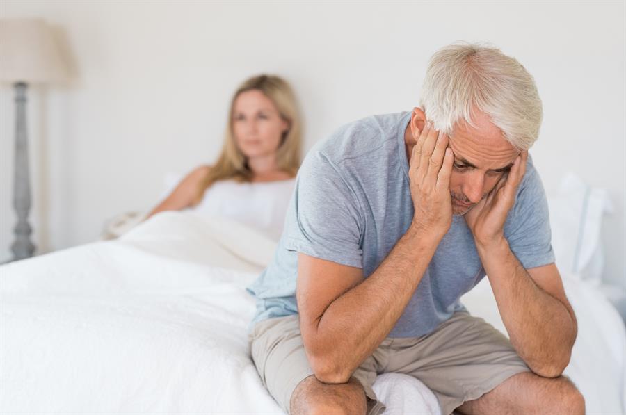 Middle aged couple unhappy in bed.