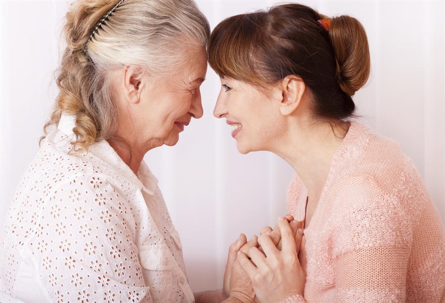 Senior woman smiling at her middle aged female caregiver.