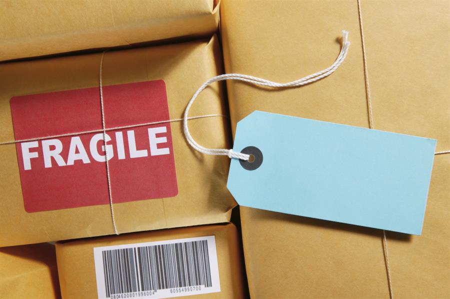 Blue tag resting on top of packages, one of which is labelled 'Fragile'.