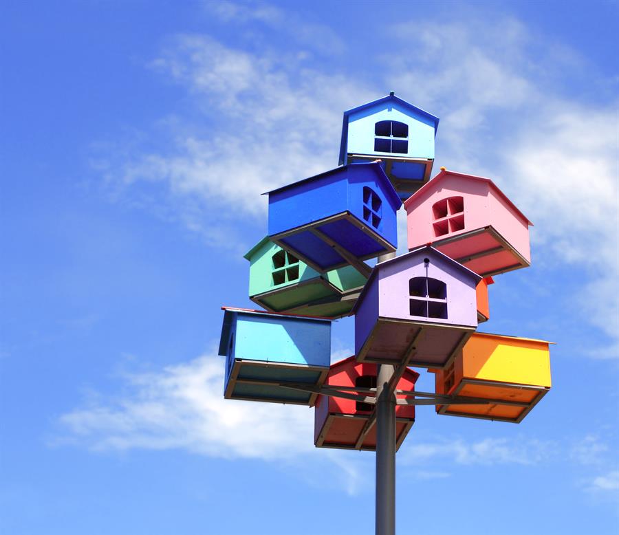 Colourful bird houses on a post.