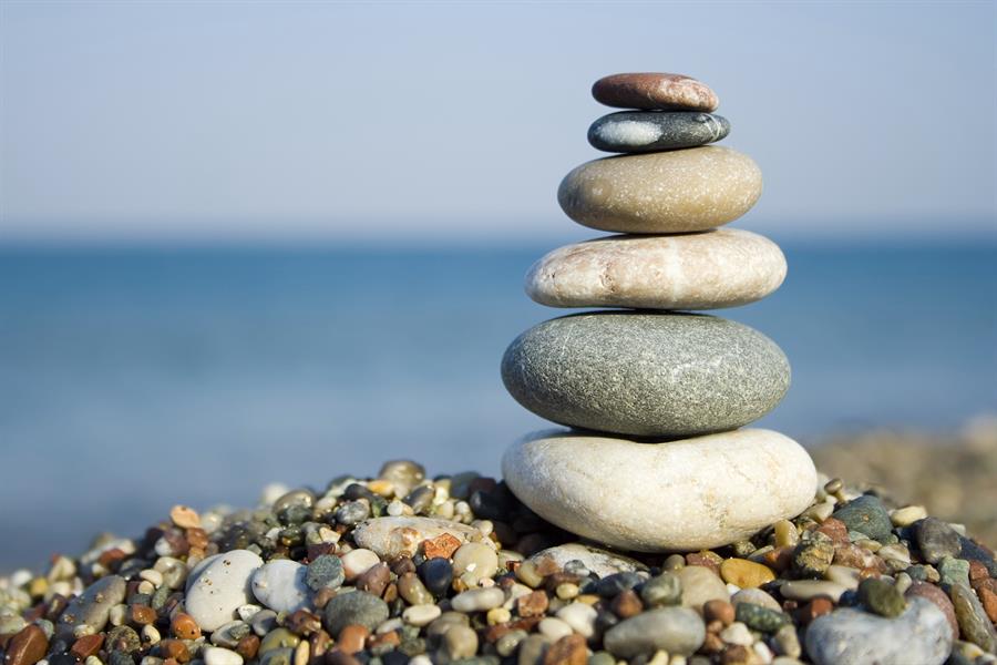 Stack of smooth stones with water in background.