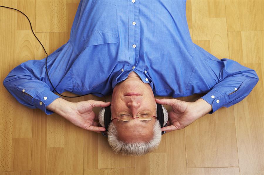 Man listening to headphones with eyes closed.