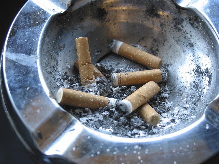 Cigarette butts extinguished in a metal ash tray.