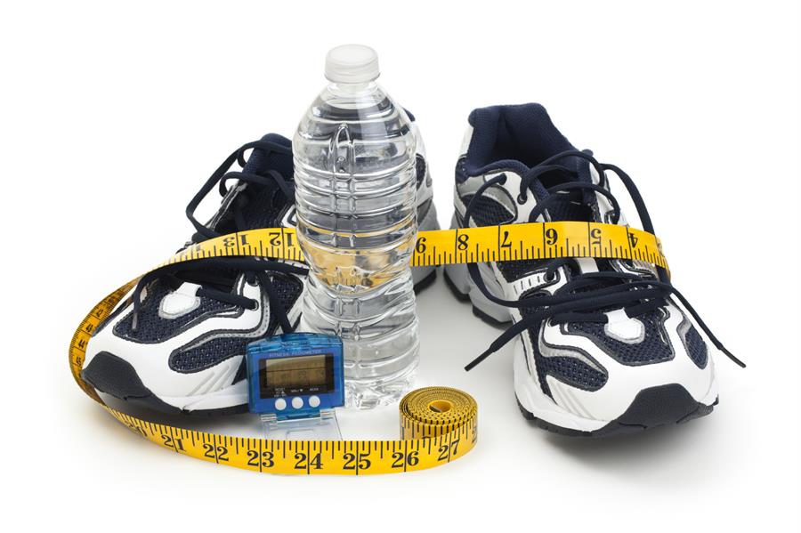 Running shoes with pedometer, water bottle and measuring tape.