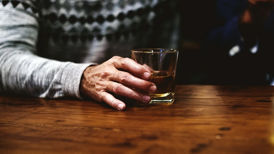 A man holding glass of whiskey