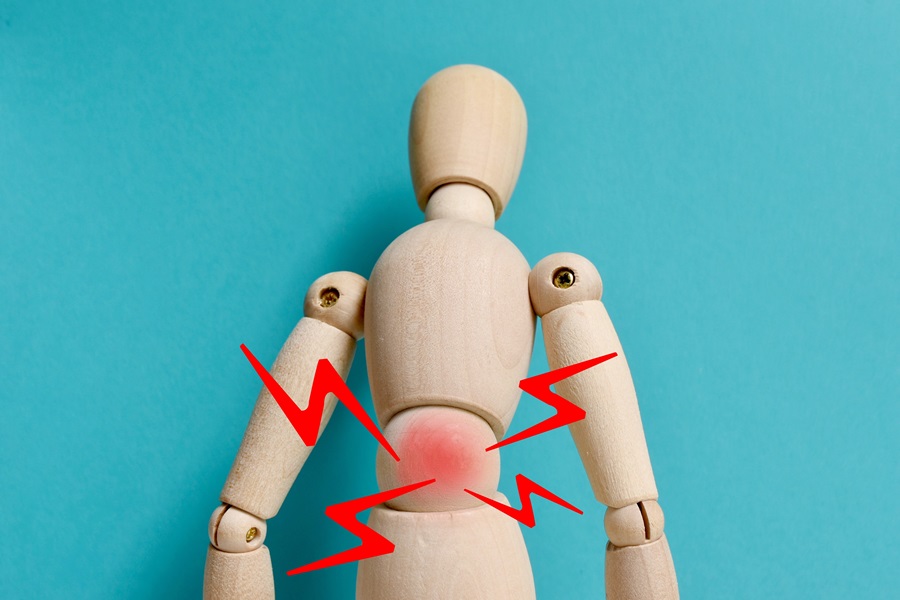 Wooden mannequin with lightening bolts signifying pain in lower back