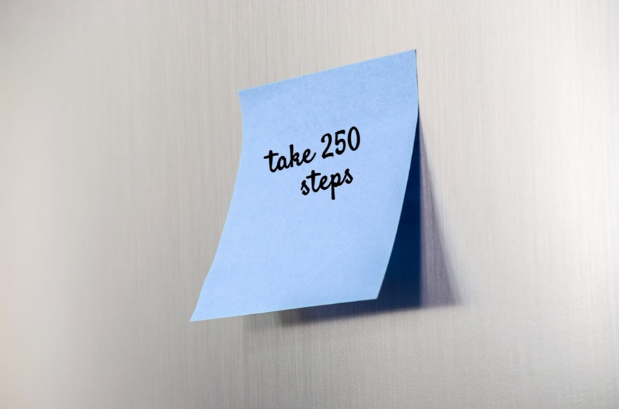 Sticky note on a fridge with a written reminder to take 250 steps