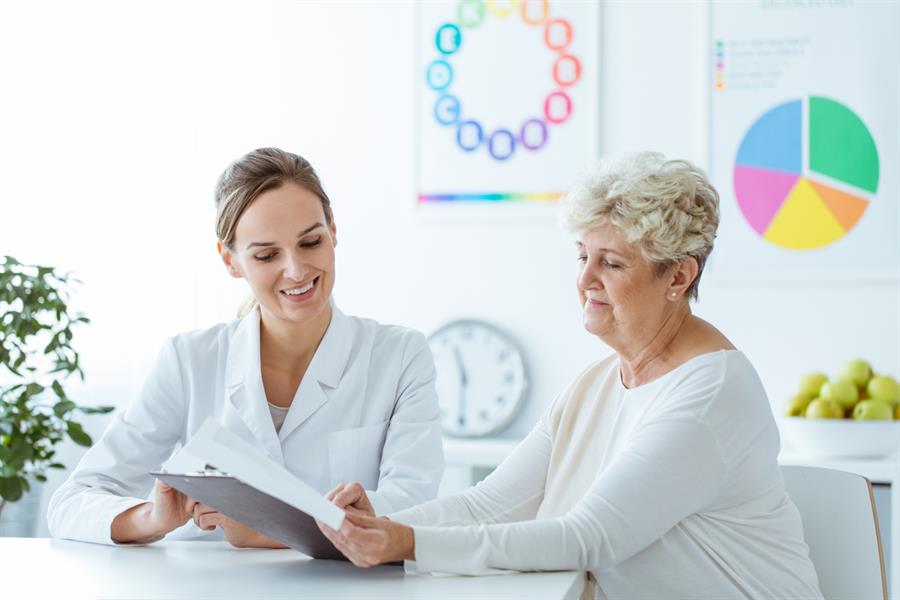 Elderly female discussing test results with her doctor. 