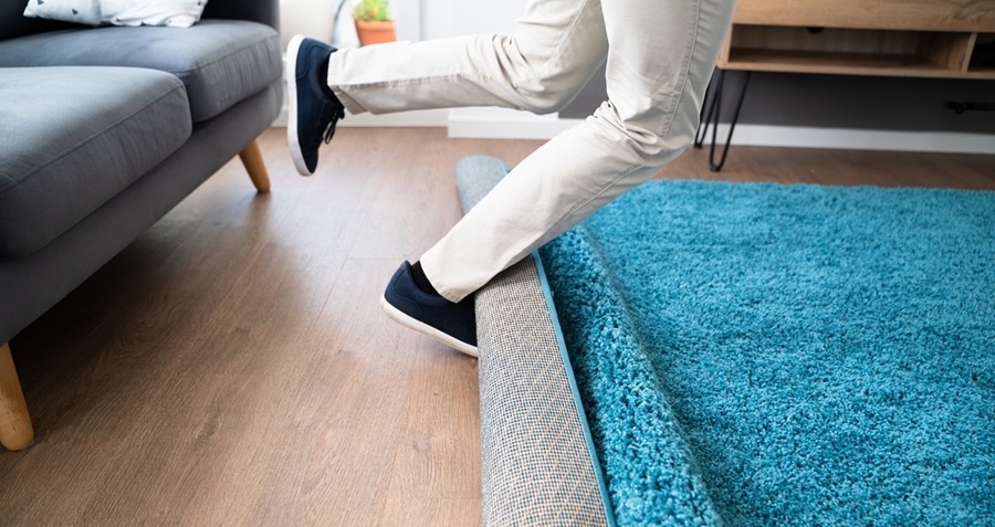 Legs tripping over a rug in a living room.