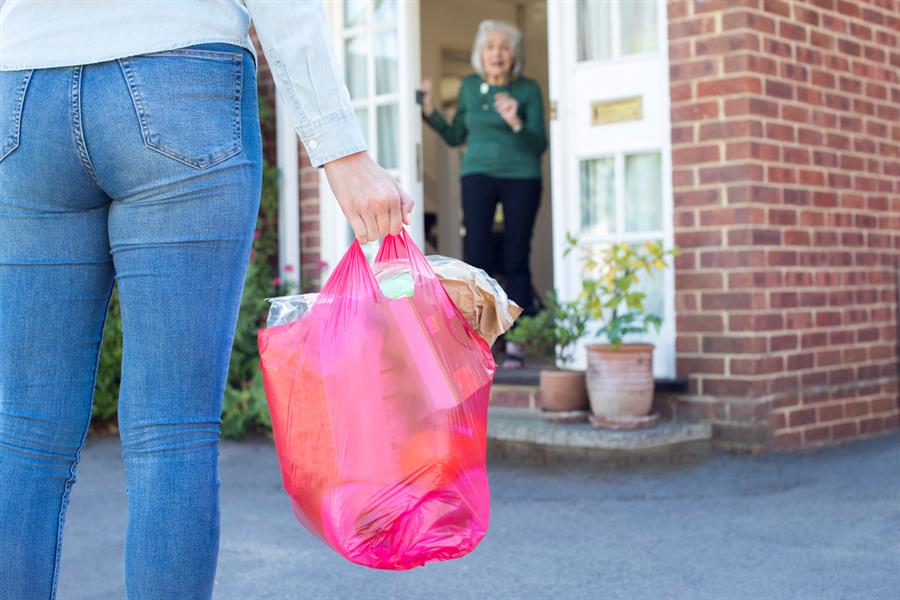 Close up of a woman doing grocery shopping for her senior neighbour.