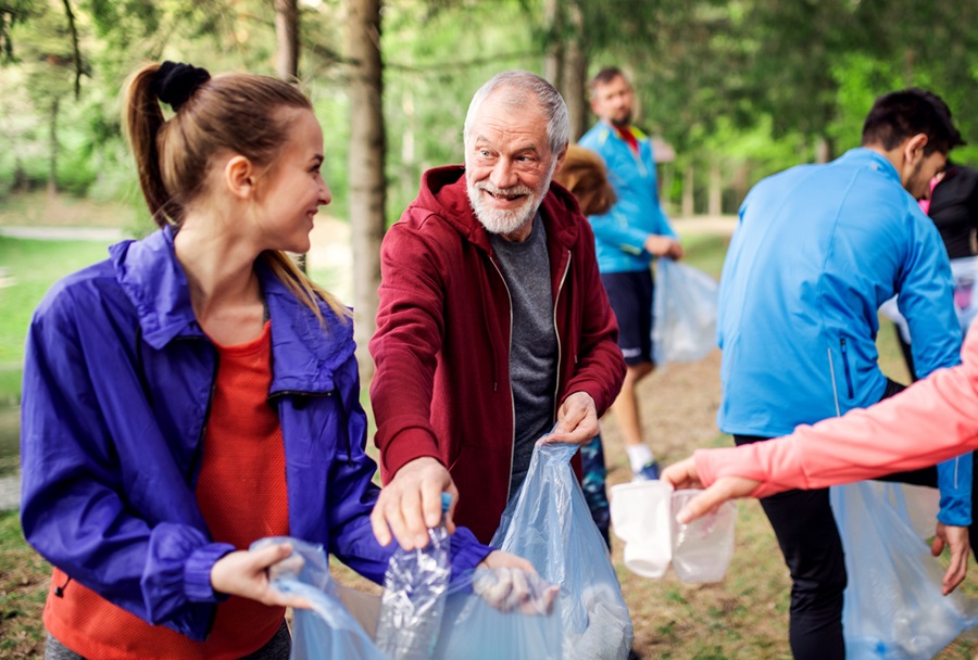 A group of community members picking up litter in nature.