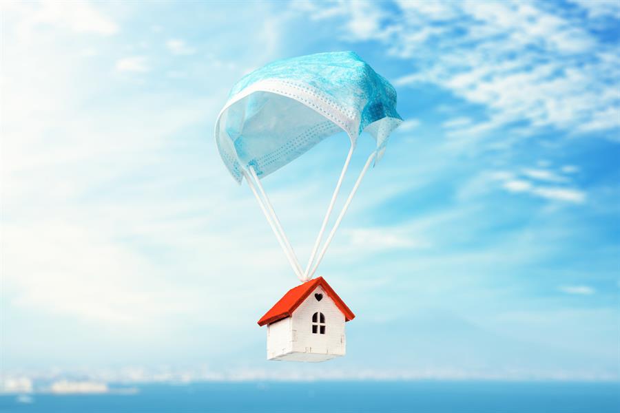 A toy house flies on a parachute from a medical mask.