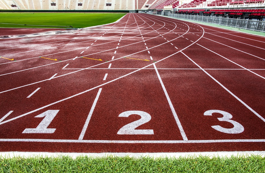 Starting line of red running track in a large stadium.