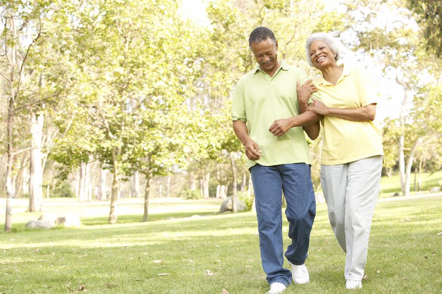 Smiling senior couple enjoying a walk together in the park.