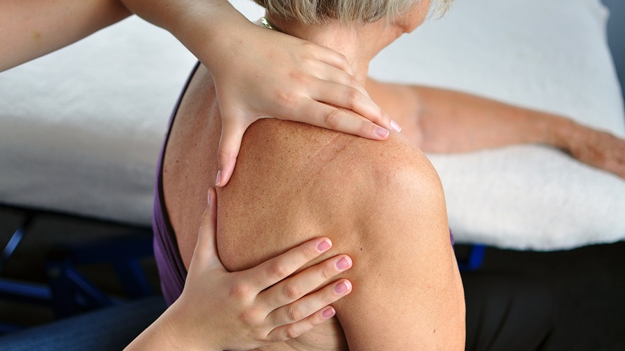 Woman receiving massage treatment for frozen shoulder