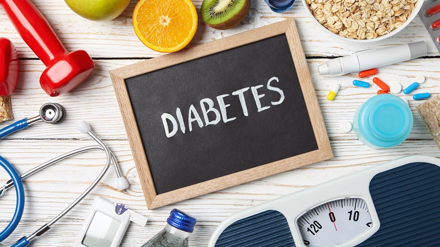 The word diabetes on a blackboard surrounded with images of healthy life style factors like nutrition, weight, and exercise